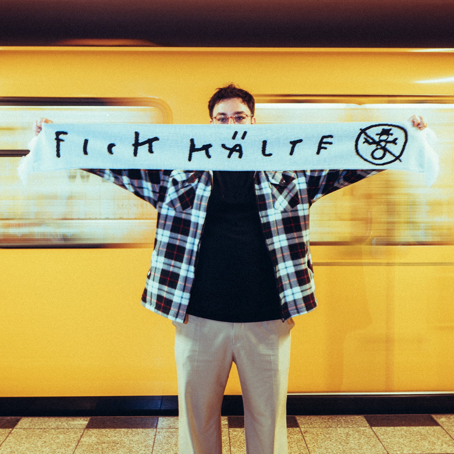 Vorderseite des gleichen weißen Schals mit dem provokanten Schriftzug „FICK KÄLT“ in schwarzer Handschrift sowie einem durchgestrichenen Schneemann-Symbol.
