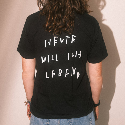 Rückenansicht: schwarzes T-Shirt mit großem weißen Statement-Print „HEUTE WILL ICH LEBEN“.