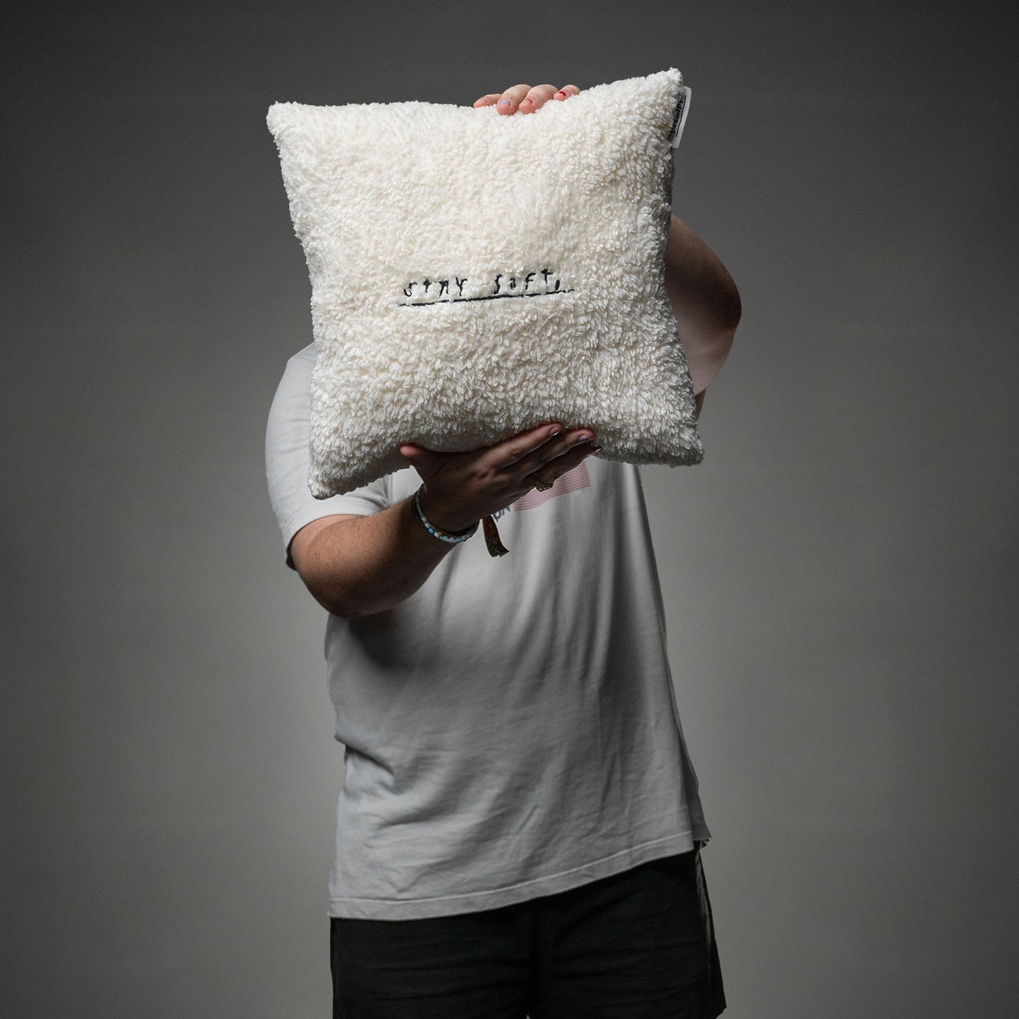 Das weiche, cremeweiße Kissen mit schwarzer Stickerei „STAY SOFT,“