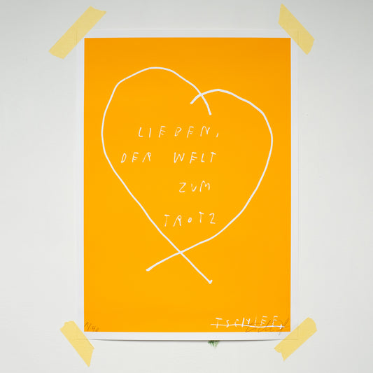 Leuchtend orangefarbenes Poster, an den Ecken mit Klebestreifen an einer weißen Wand befestigt. In der Mitte ist ein großes, weiß gezeichnetes Herz zu sehen, das sich nach unten kreuzt. Im Inneren des Herzens steht handschriftlich in Weiß: „LIEBEN, DER WELT ZUM TROTZ“. Unten links ist eine handschriftliche Editionsnummer „14/40“, unten rechts eine Signatur in Weiß zu erkennen.