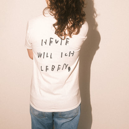 Studio, Frontansicht: weißes T-Shirt mit kleinem zentralen Schriftzug „FREUNDE FÜRS LEBEN × TSCHIFF“.