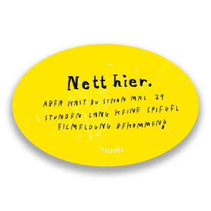 Gelber, ovaler Aufkleber mit schwarzem Schriftzug „Nett hier.“ Darunter handschriftlich ergänzt in Schwarz: „Aber hast du schon mal 24 Stunden lang keine Spielfilmmeldung bekommen?“ Unten steht klein „TSCHIEF“. Im Hintergrund unscharf weitere gelbe Aufkleber.