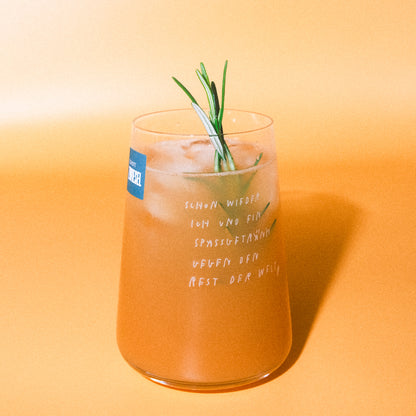 Gleiches Glas mit Eis und Rosmarin vor orangem Hintergrund; kleiner blauer Aufkleber am Rand, weißer Textaufdruck wie oben.