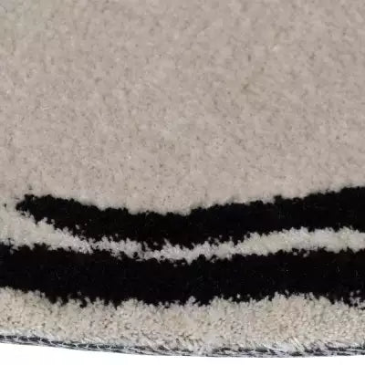 „Nahaufnahme der Teppichkante zeigt den dichten, flauschigen Flor in hellem Beige mit schwarzem Rand.“
