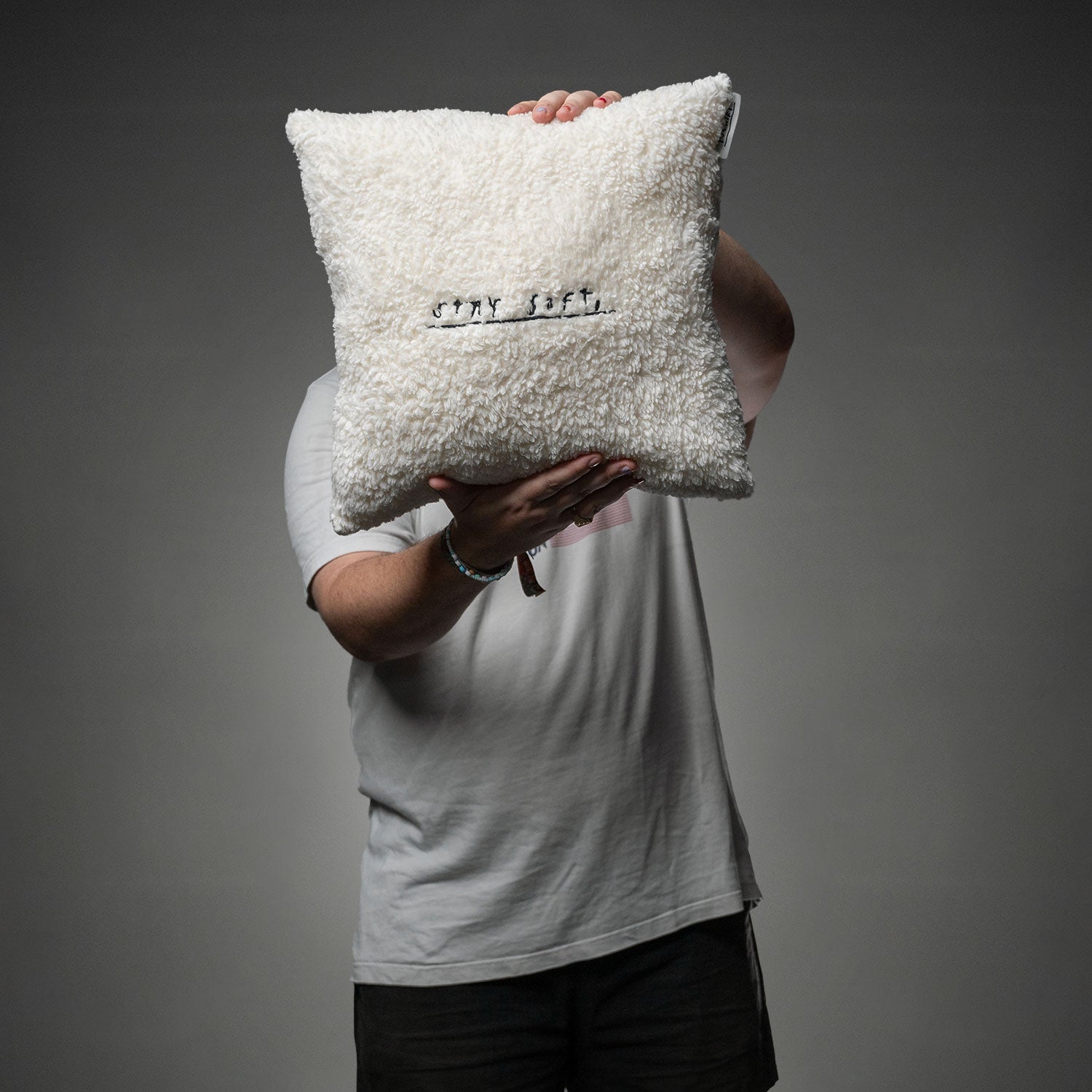 Das weiche, cremeweiße Kissen mit schwarzer Stickerei „STAY SOFT,“