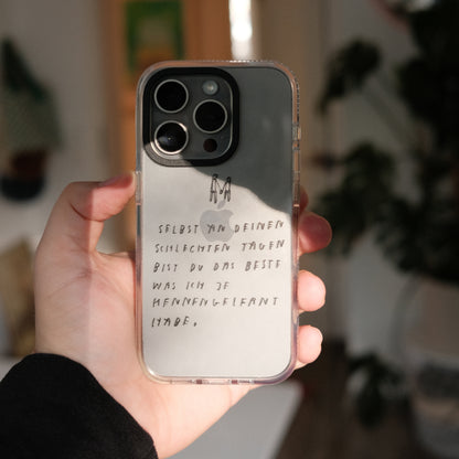 Nahaufnahme einer transparenten Handyhülle mit schwarzer Handschrift. Auf der Hülle steht:
„Selbst an deinen schlechten Tagen bist du das Beste, was ich je kennengelernt habe.“
Darüber sind zwei kleine, minimalistische Figuren, die sich an den Händen halten, gezeichnet.
