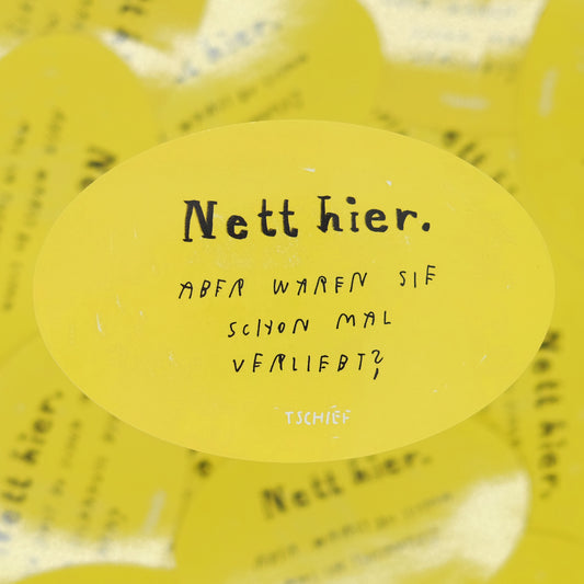 Gelber, ovaler Aufkleber mit schwarzem Schriftzug „Nett hier.“ Darunter handschriftlich ergänzt in Schwarz: „Aber waren Sie schon mal verliebt?“ Unten steht klein „TSCHIEF“. Im Hintergrund unscharf weitere gelbe Aufkleber.