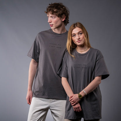 Zwei Personen tragen ein locker geschnittenes, graues T-Shirt aus Baumwolle mit schwarzem Frontprint. Die schlichte, minimalistische Typografie auf der Vorderseite zeigt den Satz „YESTERDAY WAS SO MUCH“. Die Rückseite des Shirts ist unbedruckt. Das Design wirkt zurückhaltend, modern und unaufdringlich.