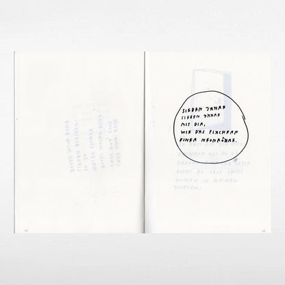 Aufgeschlagenes Notizbuch mit handschriftlichem Text auf der rechten Seite, eingekreist: „SIEBEN JAHRE SIEBEN JAHRE MIT DIR, WIE DAS FLACKERN EINER NEONRÖHRE.“ Der Hintergrund ist hell, der Text schwarz, die linke Seite bleibt nahezu leer.